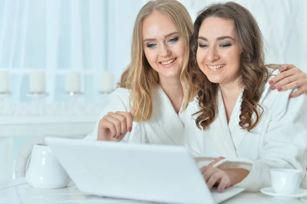 Dizüstü bilgisayarı olan bornozlu genç kadınlar — Stok fotoğraf