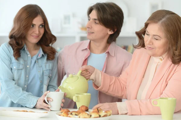 Lächelnde Dreiköpfige Familie Bei Keksen Und Tee Abendbrottisch — Stockfoto