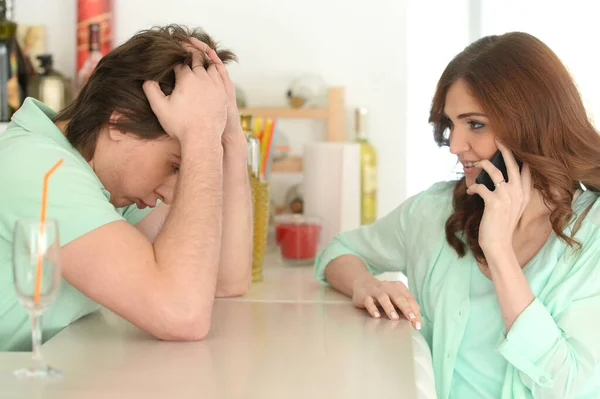 Entediado Jovem Esperando Enquanto Sua Namorada Falando Smartphone — Fotografia de Stock