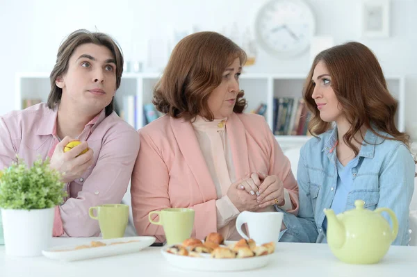 3人家族でクッキーと紅茶と一緒に食卓に並び — ストック写真