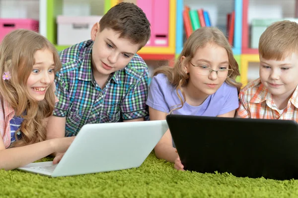 Bir Grup Çocuk Yeşil Halıyla Yerde Yatıp Modern Laptoplara Bakıyorlar — Stok fotoğraf