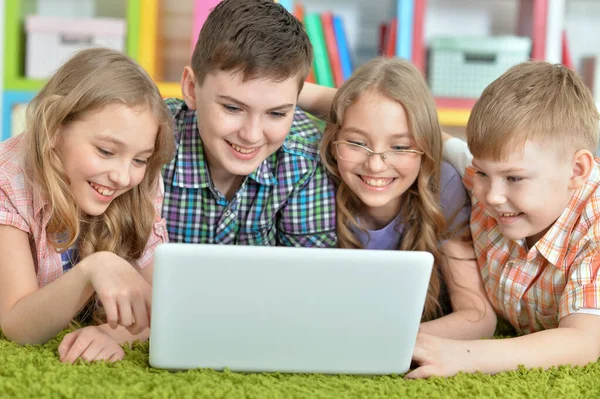 Grupa Dzieci Leżących Podłodze Zielonym Dywanem Patrzących Nowoczesny Laptop — Zdjęcie stockowe