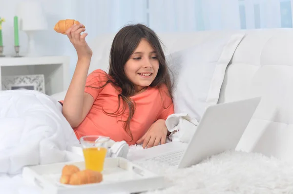Девочка Лежит Мягкой Бежевой Кровати Ноутбуком Завтракает — стоковое фото