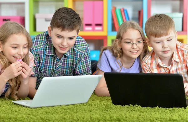 Группа Детей Лежит Полу Зеленым Ковром Смотрит Современные Ноутбуки — стоковое фото