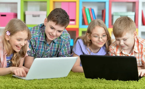 Grupo Niños Tumbados Suelo Con Alfombra Verde Mirando Las Computadoras — Foto de Stock