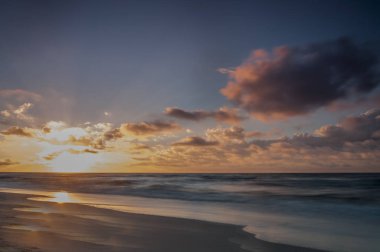 Yaz. Denizin kenarında renkli günbatımı