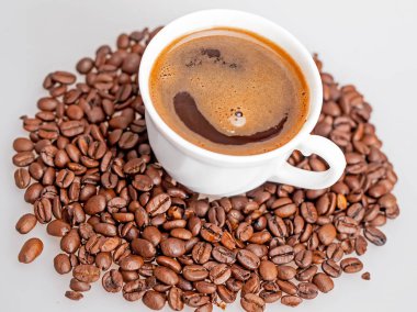 Kahve çekirdekleri ile çevrili bir fincan sıcak kahve