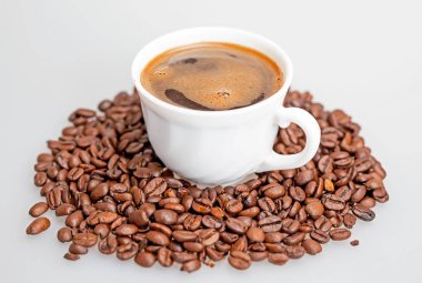 Kahve çekirdekleri ile çevrili bir fincan sıcak kahve