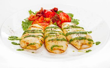 Sebzeli bir tabakta kızartılmış kalamarlar.