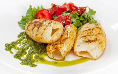 Sebzeli bir tabakta kızartılmış kalamarlar.