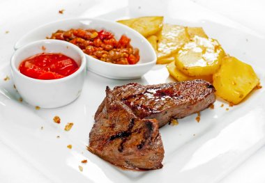 Et yemekleri, kebaplar, bishtex, soslar ve çeşitli kruton ile bir tabak.