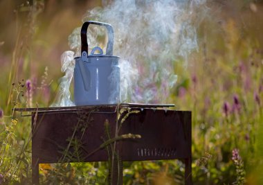 Izgarada kaynayan su ısıtıcısı, açık havada.