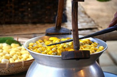 Tencerede kaynamış ipek böceği kozaları iplik üretmek için liflere ayrılır..