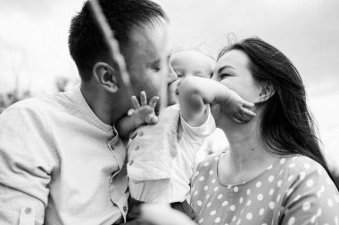 Ebeveynler oğluyla yaz günü çayırda oynarken eğleniyorlar.