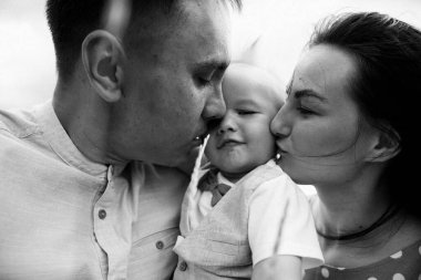 Ebeveynler oğluyla yaz günü çayırda oynarken eğleniyorlar.