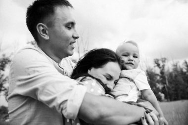 Ebeveynler oğluyla yaz günü çayırda oynarken eğleniyorlar.