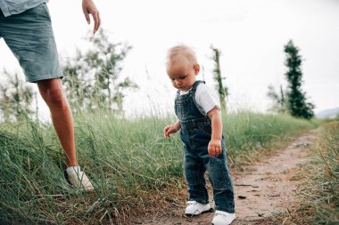Baba ve oğul yaz günü çayırda birlikte oynuyorlar. 