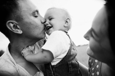 Ebeveynler oğluyla yaz günü çayırda oynarken eğleniyorlar.