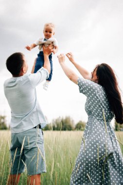 Ebeveynler yaz günü oğlunu çayırda oynuyorlar ve kusuyorlar.