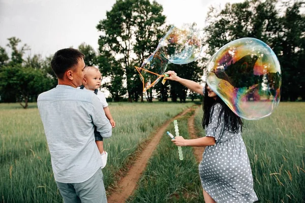 Felizes Jovens Pais Filho Divertindo Enquanto Brincava Com Bolhas Sabão — Fotografia de Stock