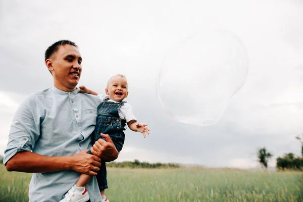 Pai Segurando Filho Mãos Enquanto Brincava Com Bolha Sabão Juntos — Fotografia de Stock