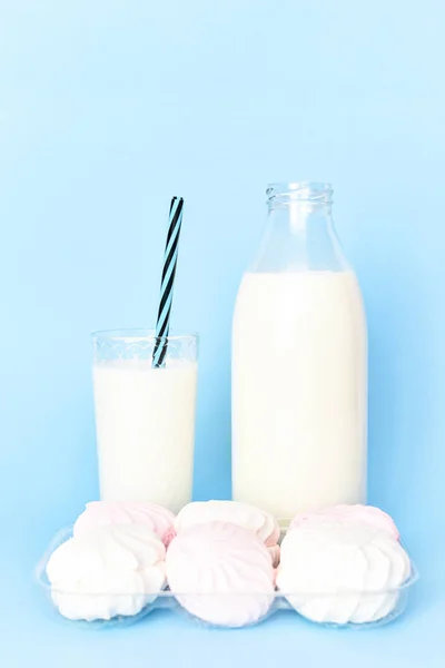 Mjölk i en klart glasflaska och ett glas glas glas Cup med en tub och en marshmallow-paketet — Stockfoto