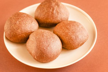 Kahverengi zemin üzerine beyaz tabakta çavdar ekmeği