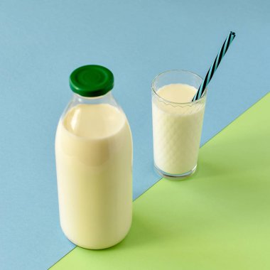 Cam şişe ve saman ile şeffaf bir bardak süt 