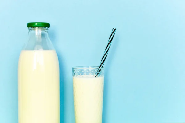 Lait dans une bouteille en verre et un verre transparent avec paille — Photo