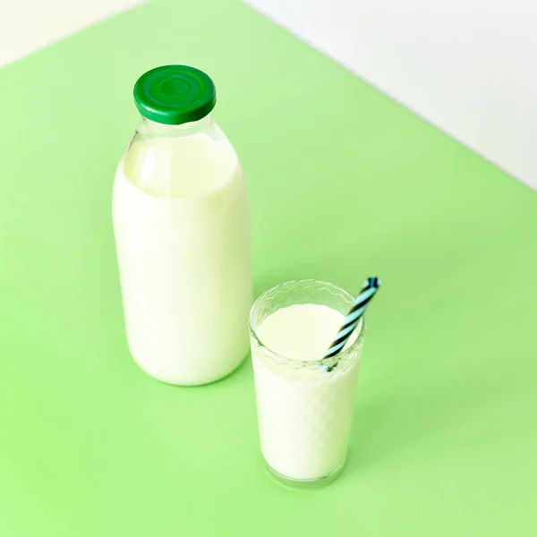 Молоко в стеклянной бутылке и прозрачное стекло с соломой — стоковое фото