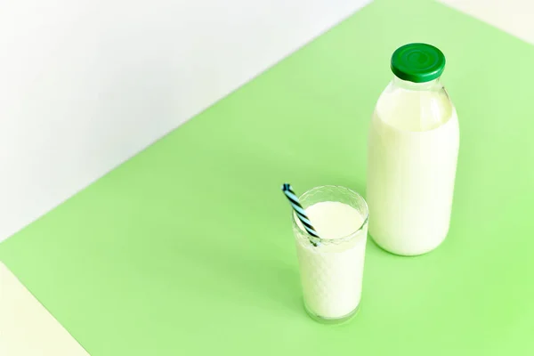 Milk in a glass bottle and a transparent glass with straw — Stock Photo, Image
