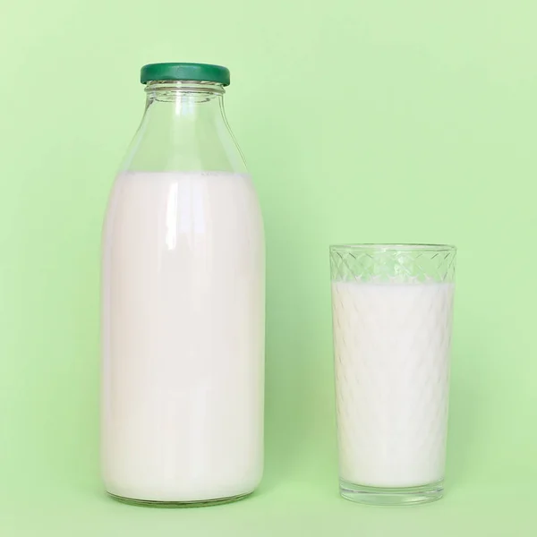 Latte in bottiglia di vetro e bicchiere trasparente con paglia — Foto Stock