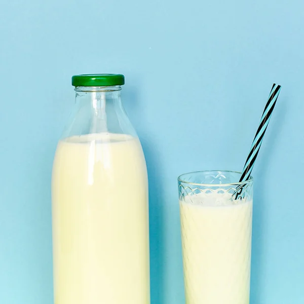 Lait dans une bouteille en verre et un verre transparent avec paille — Photo