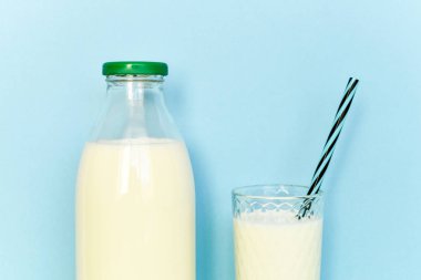 Cam şişe ve saman ile şeffaf bir bardak süt 