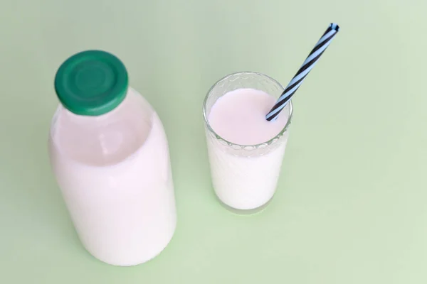 玻璃瓶中的牛奶和带有稻草的透明玻璃杯 — 图库照片