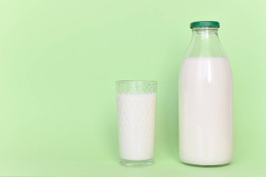 Cam şişe ve saman ile şeffaf bir bardak süt 