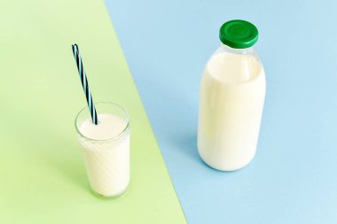 Cam şişe ve saman ile şeffaf bir bardak süt 