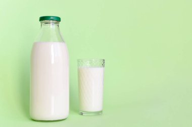 Cam şişe ve saman ile şeffaf bir bardak süt 