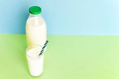 Cam şişe ve saman ile şeffaf bir bardak süt 