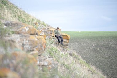 Tek tip bir kayaya oturan bir adam