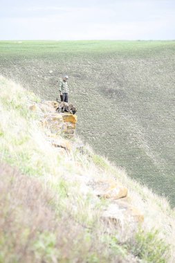 Bir adam ve bir köpek küçük bir kaya üzerinde durmak