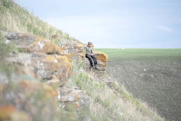 Tek tip bir kayaya oturan bir adam