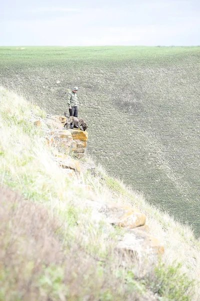 Bir adam ve bir köpek küçük bir kaya üzerinde durmak