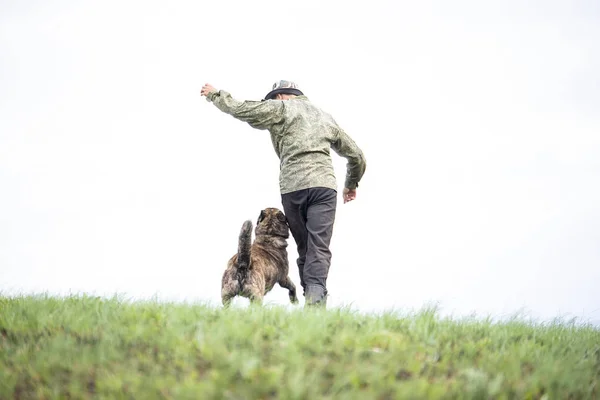 Onbekende man in uniform en een hond. — Stockfoto