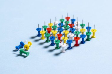 İğneler çok renkli ileti örneği düğmeleri mavi bir arka plan üzerinde yığılmış