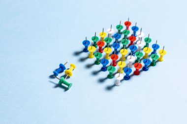 İğneler çok renkli ileti örneği düğmeleri mavi bir arka plan üzerinde yığılmış