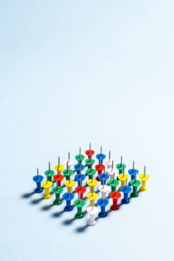 İğneler çok renkli ileti örneği düğmeleri mavi bir arka plan üzerinde yığılmış