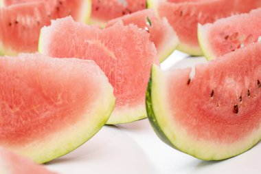 Beyaz bir tablo üzerinde kırmızı lezzetli sulu karpuz dilimleri