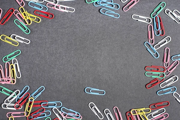 Multi-colored beautiful stationery paper clips on black background
