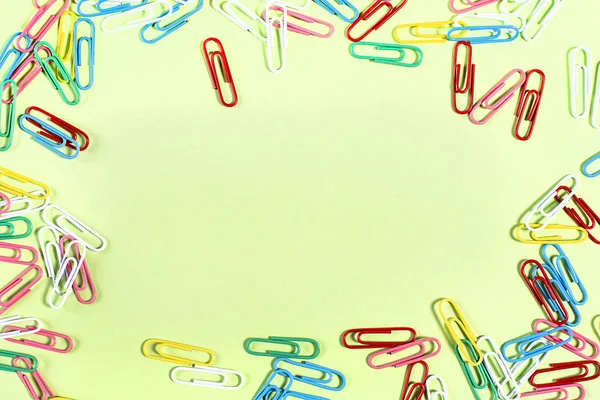 Multi-colored beautiful stationery paper clips at the edges of the surface — Stock Photo, Image